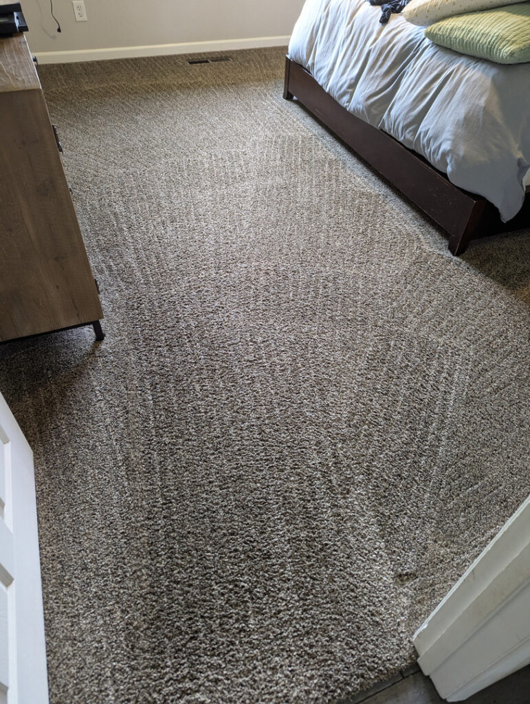 carpet cleaning in a bedroom showing clean lines on freshly cleaned carpet indicating professional service was performed